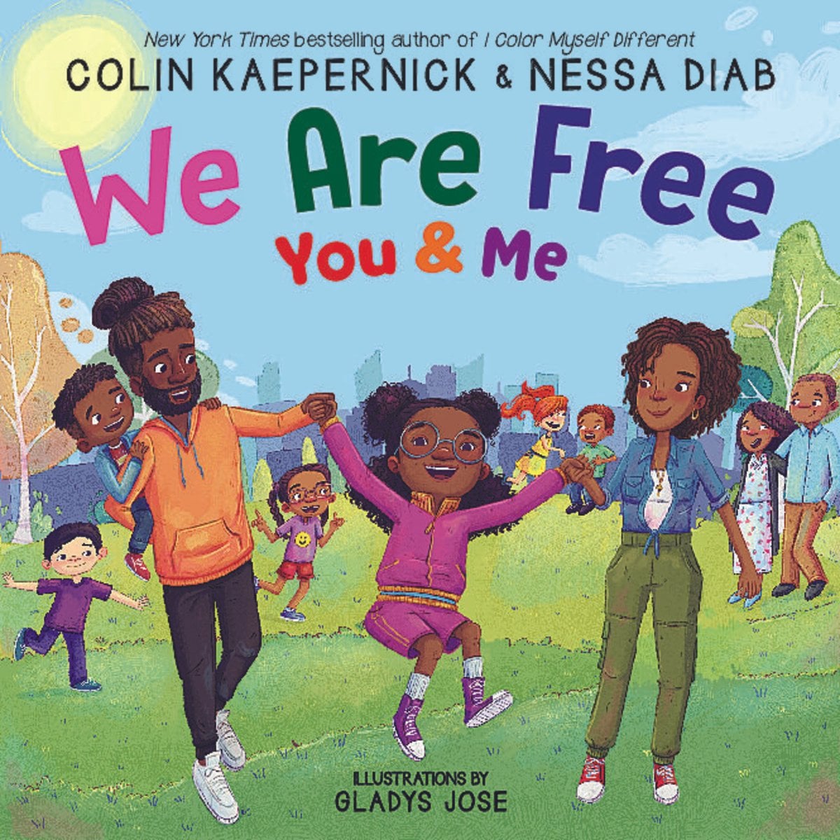 Book cover of We Are Free, You and Me, written by Colin Kaepernick and Nessa Diab, illustrated by Gladys Jose, featuring two brown-skinned adults swinging a brown-skinned child between them with their arms. The one on the right also holds a brown-skinned toddler on their hip; a diverse group of adults and children play in the background.