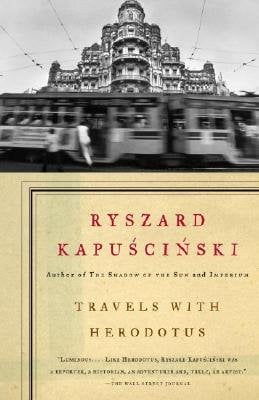 Travels with Herodotus by Ryszard Kapuściński, book cover. A black-and-white image of a historical building and a train passing by fast in front of it is on the top half of the cover. The bottom half is an antique-colored page that has the title and author's name on it.
