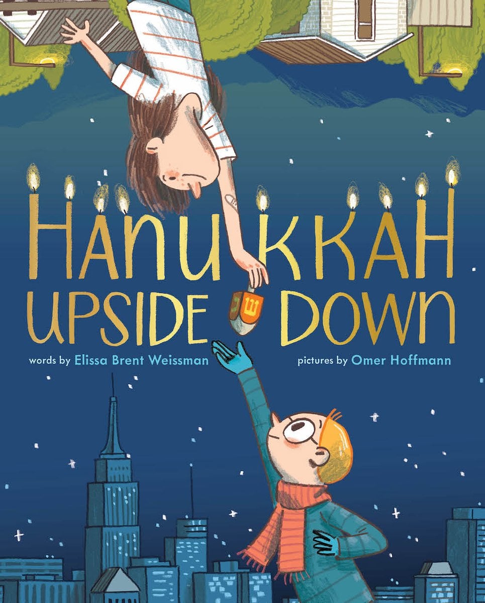 Hanukkah Upside Down by Elissa Brent Weissman book cover features two children - one upside down - both reaching for each other. The child right-side up is among a dark city skyline and the other lives in grassy, rolling hills. The background goes from a light blue sky to a dark night sky.