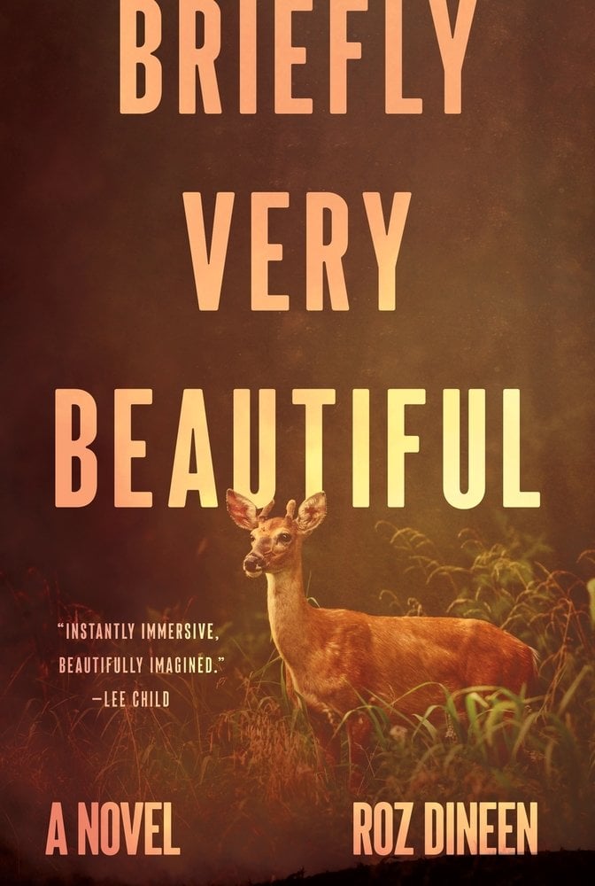 Briefly Very Beautiful by Roz Dineen book cover featuring a picture of a deer standing in the grass. The background is a faded view of the forest with a brown-gold tint to the photo.