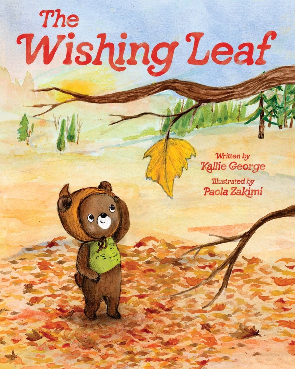Book cover of The Wishing Leaf by Kallie George, Illustrated by Paola Zakimi, featuring a brown bear wearing a knit cap and shirt and standing on hind legs as it gazes up at a yellow leaf clinging to the branch of a tree; the cub if surrounded by fallen leaves in autumn colors.