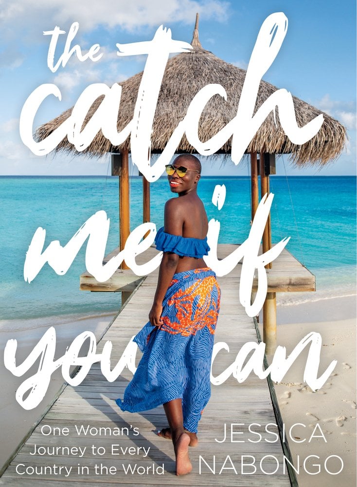 The Catch Me If You Can by Jessica Nabongo, a travel guide depicting a woman on a beach look directly at the viewer. She is walking on a pier towards a covering and is wearing a royal blue top and colorful pants. The title and author's name are in white cursive text across the entire cover.