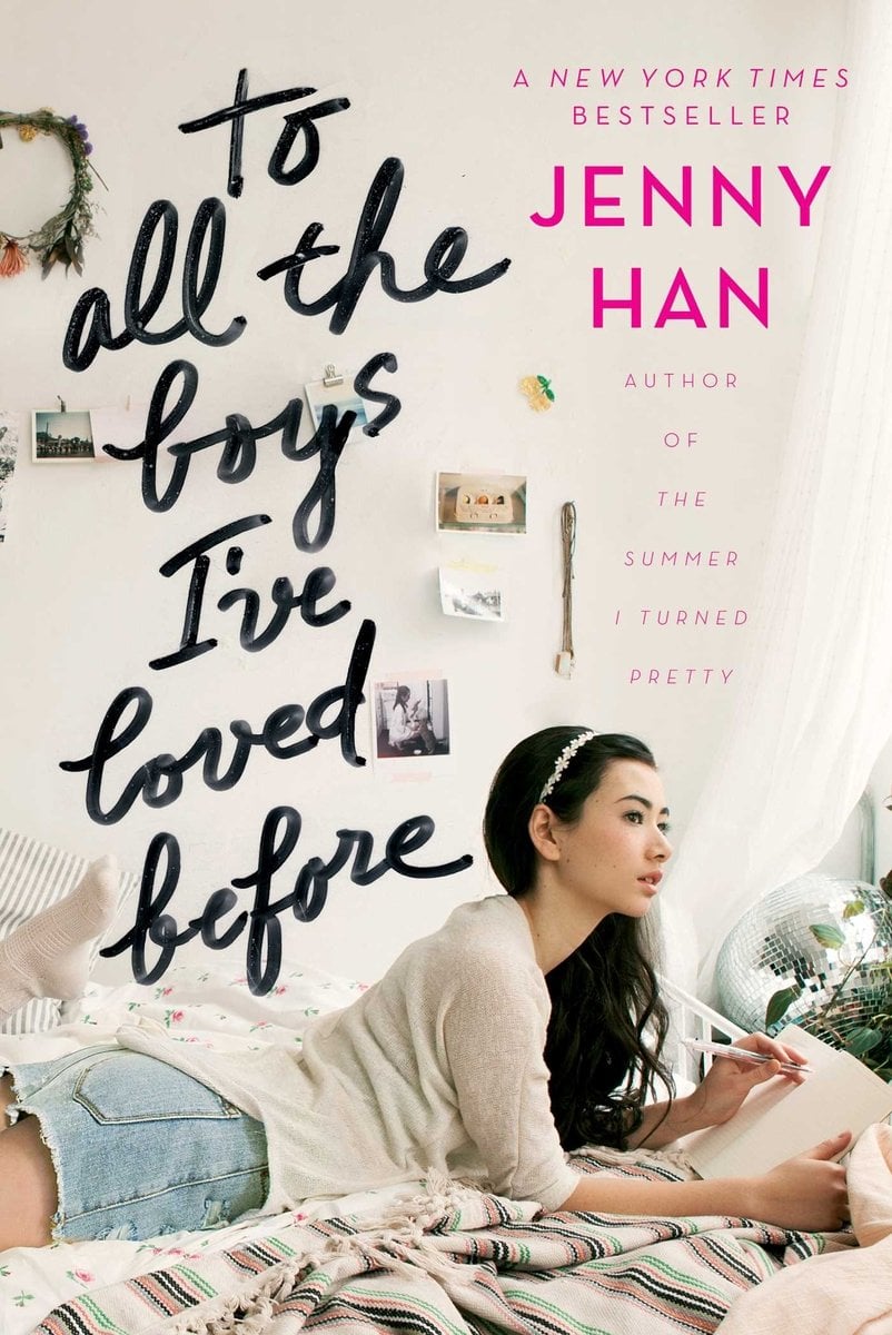 The cover of To All the Boys I Loved Before, a YA romance, depicts a young girl in jean shorts and white headband leaning on a bed with a pen in onehand over a blank notebook.