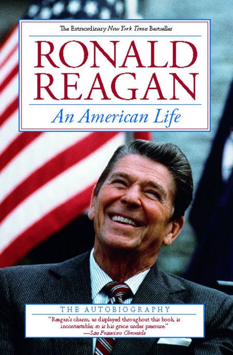 Ronald Reagan: An American Life by Ronald Reagan, book cover. Middle aged man with grayish-brown hair smiles while looking up. An American flag is set in the background. The author's name is in big, red text, while the title is light blue and italicized.