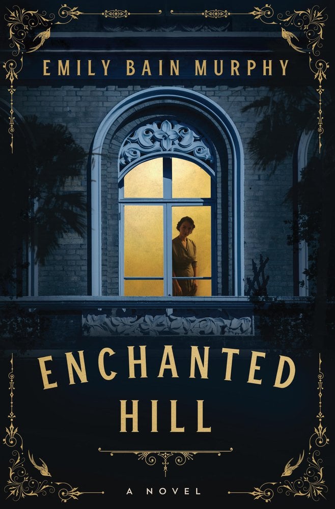 Enchanted Hill by Emily Bain Murphy book cover features a woman standing in a golden lit window looking out. Decorative gold filigree accents line the edges of the cover, imparting an air of elegance and vintage glamour. The stone façade of the building framing the window is in blues and grays, in a aura of quiet intrigue. The title, Enchanted Hill, is rendered in bold, serif-gold lettering beneath the window. The author's name, Emily Bain Murphy, is in the same lettering at the top.