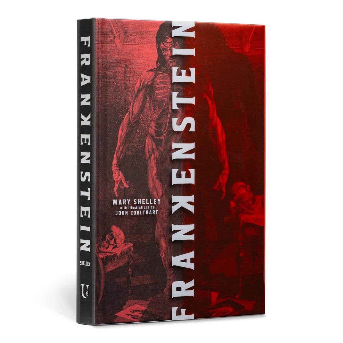 Frankenstein, a classic gothic literature novel by Mary Shelley, illustrated edition book cover showing the artist's adaptation of the towering monster with shaggy black hair and muscles and bones exposed. The monster is in a wooden room with skulls and what seems to be a deceased person in the background. The title text goes straight down the middle of the cover splitting it in half.