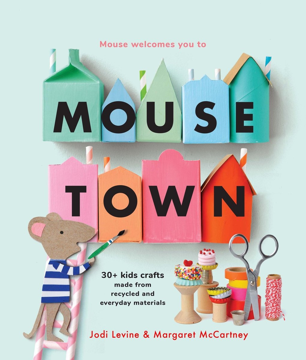 Book cover of "Mousetown: 30+ Kids Crafts Made from Recycled and Everyday Materials" by Jodi Levine and Margaret McCartney, featuring a small brown mouse wearing a blue-and-white striped shirt climbing a ladder and painting a collection of crafted houses.