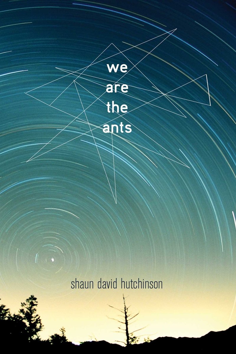 We Are The Ants by Shaun David Hutchinson book cover featuring a night-sky design unfolds with the appearance of long, circular star trails swirling across deep teal to faded aquamarine tones. Superimposed among these star arcs are thin, angular line constellations in white, giving the impression of celestial geometry or ethereal connections. Centered vertically and offset slightly to the left, the title "we are the ants" is set in lowercase white letters with a clean, minimalist font. Near the bottom edge, the author’s name “shaun david hutchinson” appears in a small, subtle font.