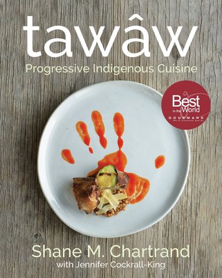 Tawâw: Progressive Indigenous Cuisine by Shane M Chartrand, an Indigenous cookbook, cover depicting the chef's famous award winning dish War Paint in which orange sauce looks like a hand print underneath uniquely plated meat and vegetables.