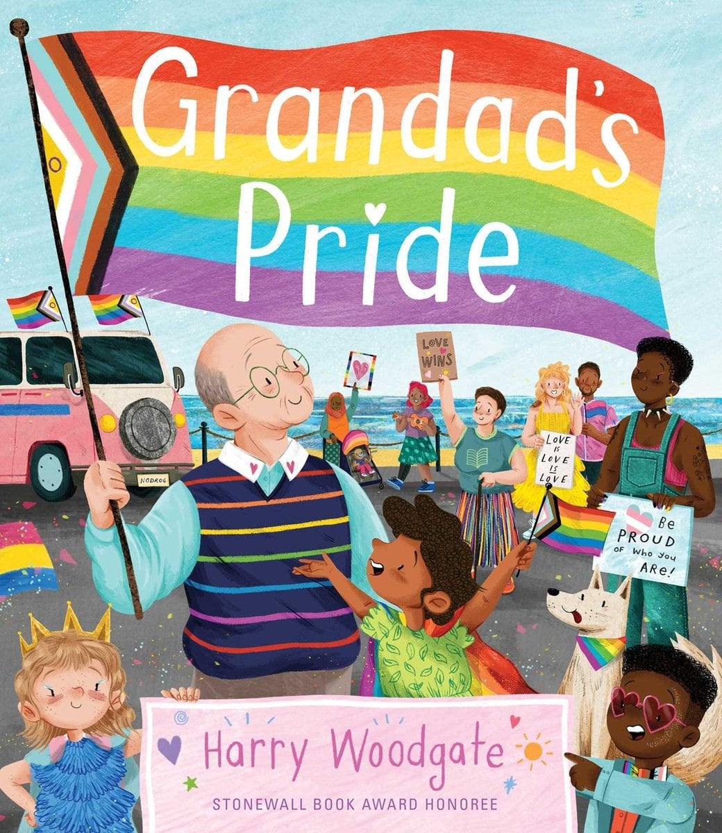 Book cover of Grandad's Pride by Harry Woodgate, featuring a light-skinned elderly man with a bald head and blue eyeglasses and a brown-skinned child with short, curly brown hair celebrating at a Pride march by the sea.