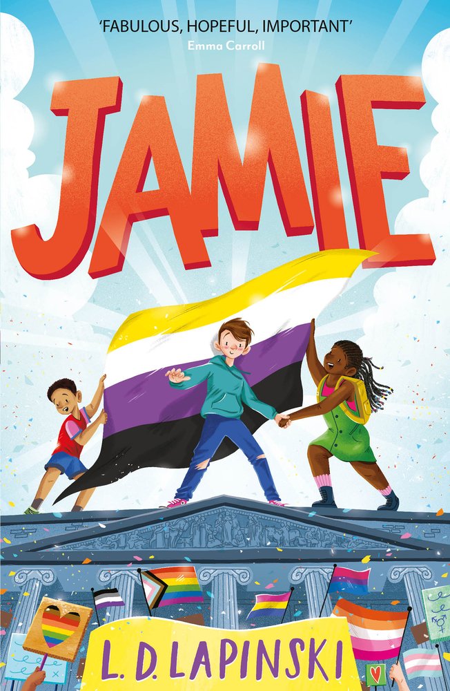 The book cover of "Jamie" by L. D. Lapinski features a pale-skinned child with short brown hair standing on top of a building; behind them, a tan-skinned friend and dark-skinned friend hold up both ends of a nonbinary pride flag to act as a backdrop; below, a crowd of people hold up various LGBTQ+ identity pride signs.
