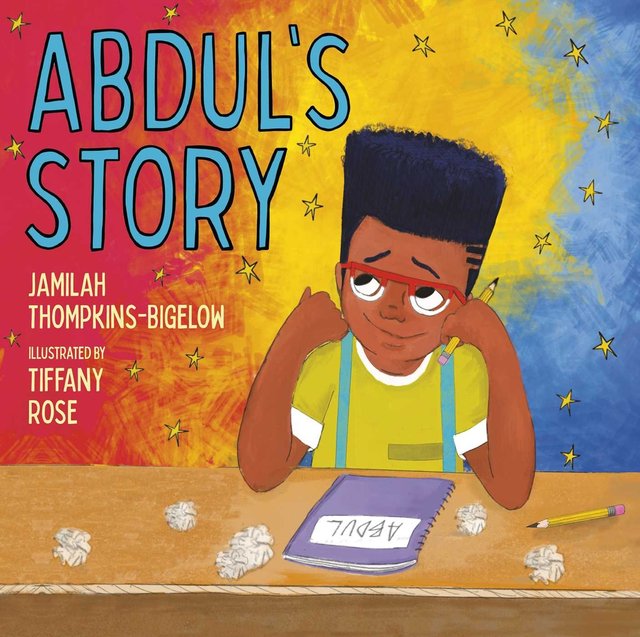 Abdul's Story by Jamilah Thompkins-Bigelow & Tiffany Rose shows a boy with glasses sitting at his desk and looking up to the left corner as if he's thinking with a smile. The desk holds crumpled papers, a pencil, and a notebook with the name "Abdul" written on it. The background is a vertical fade from red to yellow to blue with stars scattered around.