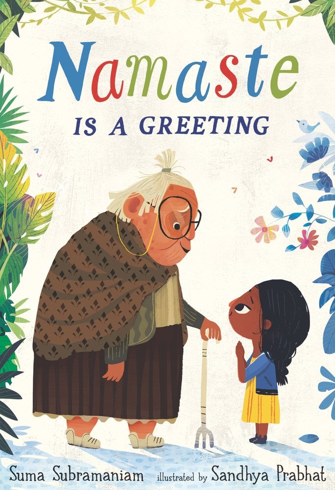 Namaste is a Greeting by Suma Subramaniam book cover features a child with dark skin and hair with an elderly woman with white hair and a cardigan pulled around her while she holds a white cane. Tropical leaves and flowers surround the cover in a frame in greens, blues, and red-pinks.