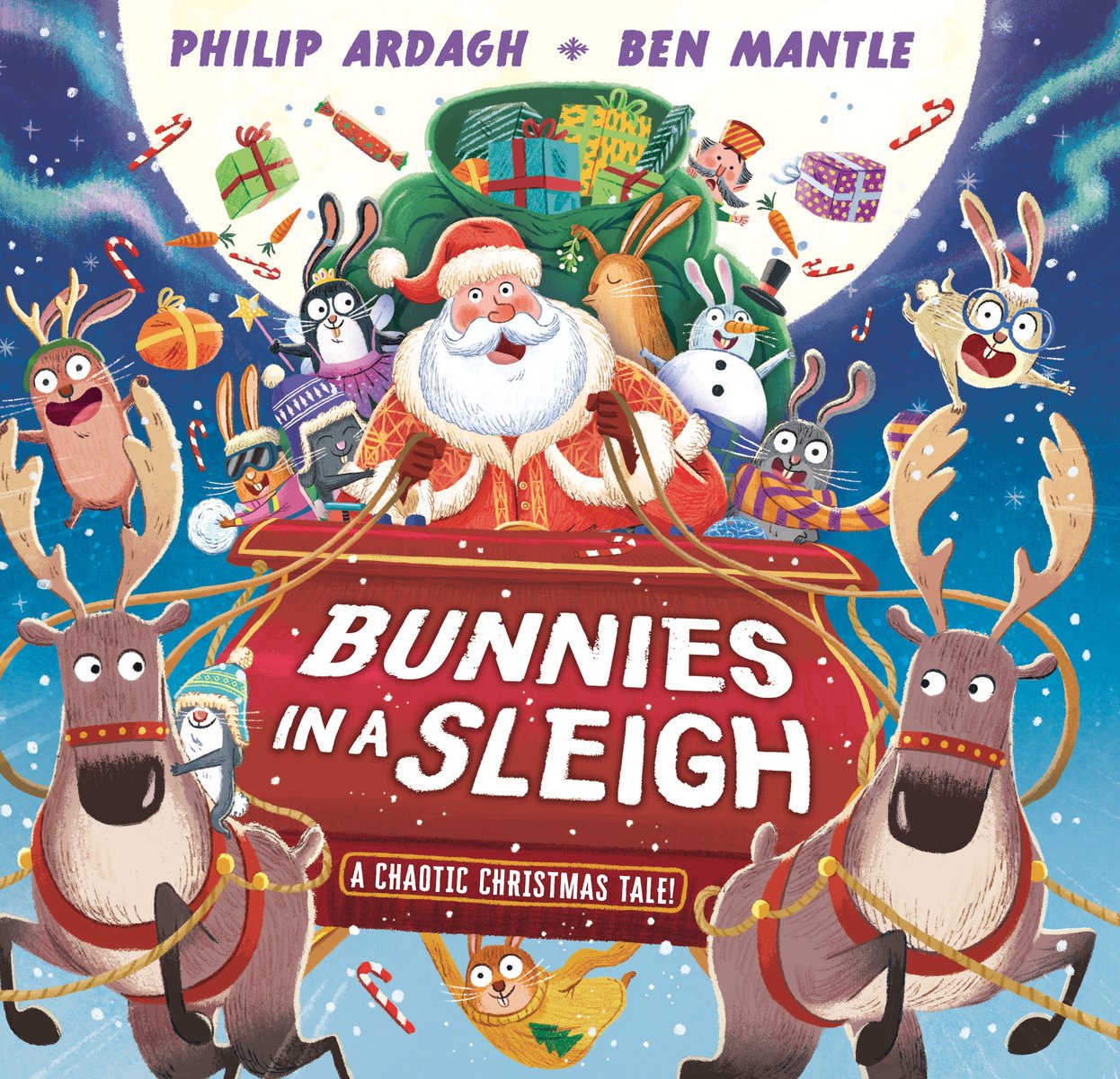 Book cover of "Bunnies in a Sleigh: A Chaotic Christmas Tale!" by Philip Ardagh & Ben Mantle, featuring a pale-skinned Santa Claus driving a sleigh with two visible reindeer; clamboring over the sleigh and reindeer are twelve bunnies of various colors as gifts, candy canes, and carrot fly from the back of the sleigh.