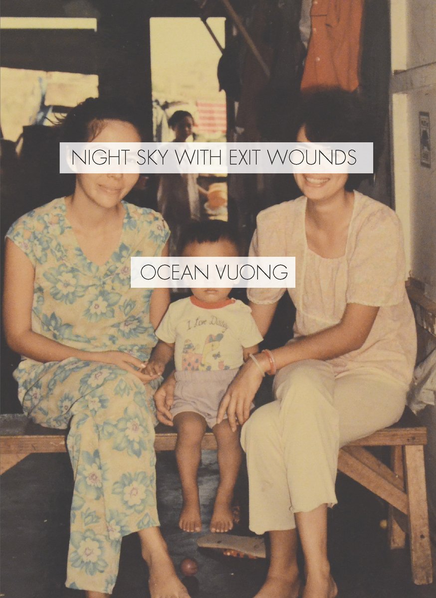 Night Sky With Exit Wounds by Ocean Vuong, a poetry book cover depicting a barefoot little boy (toddler) with short black hair, wearing a graphic t-shirt and shorts, sat on a bench between two adult women. The woman on the left has black hair tied back from her face and is wearing a flowery yellow and blue jumpsuit. The woman on the right is wearing her short black hair down and is wearing a white blouse and trousers. The title of the book and the author's name are covering the eyes of the three people in the photo. In the background, another young boy stands in an open doorway, looking towards the people having their photo taken.