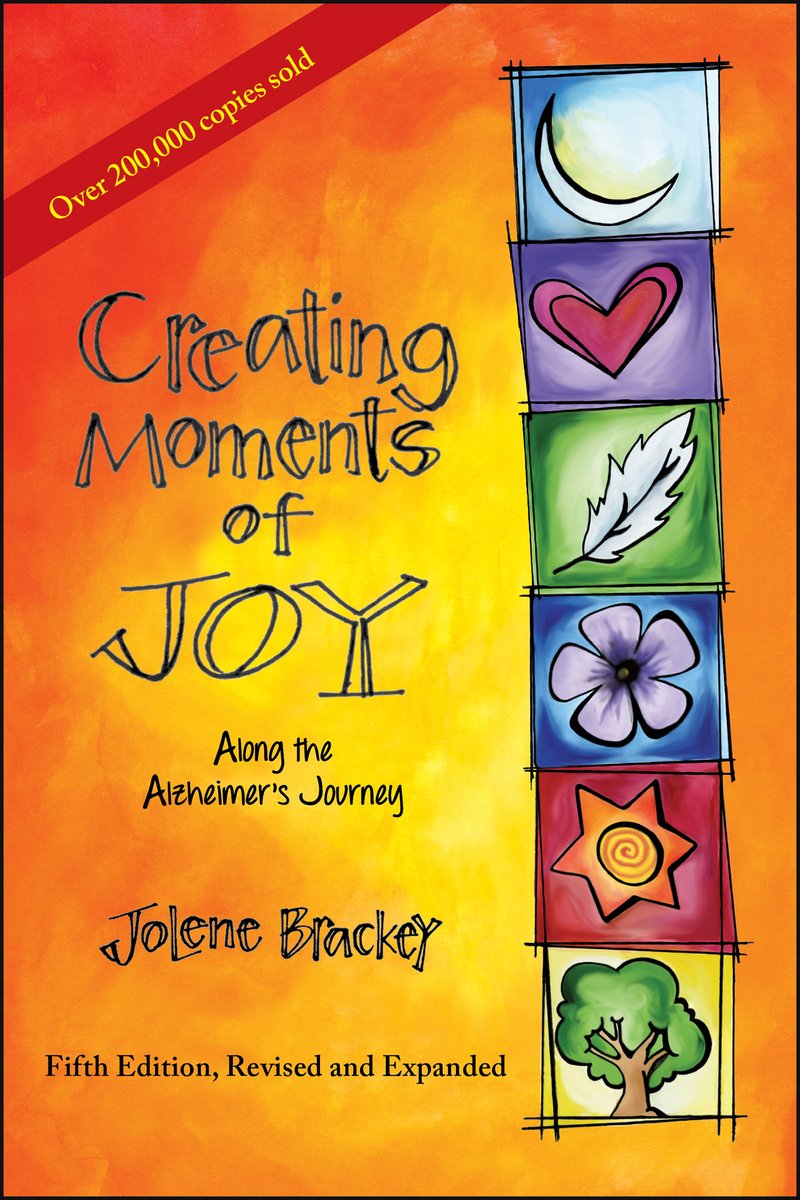 Cover of the book Creating Moments of Joy Along the Alzheimer’s Journey by Jolene Brackey. The background is orange and red, and on the right hand side of the cover are symbols stacked on top of each other. There is a moon, heart, feather, flower, sun, and tree. The title lays to the left.