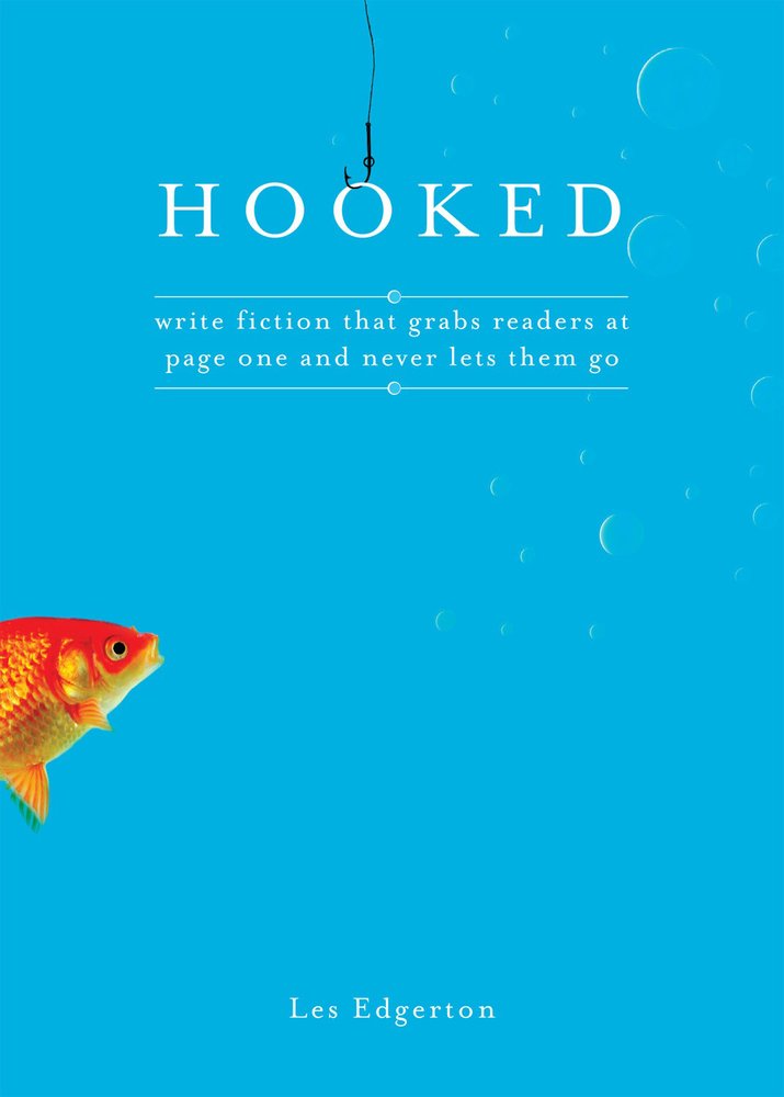 Hooked: Write Fiction That Grabs Readers at Page One & Never Lets Them Go by Les Edgerton book cover depicting a blue background with an orange fish swimming into frame from the left. At the top, a fish hook is shown hooking the second "o" in the title "Hooked."