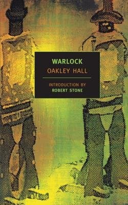 Warlock by Oakley Hall. A green and yellow cover showing the backs of two standing cowboys.