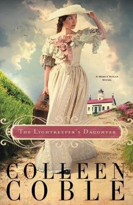 Book cover of The Lightkeeper's Daughter by Colleen Coble. A woman with brown curly hair wearing an elegant white dress with lacy white sleeves and pink roses on the collar walks with a brown luggage trunk in her hand. She wears a matching white hat and seems to be looking at something in the distance. In the background is a pale blue sky with gray storm clouds and a building with a pink roof.
