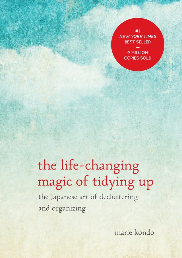 The Life-Changing Magic of Tidying Up by Marie Kondo, ombre effect of blue sky with pale color, clouds hanging in the sky, red title, book cover
