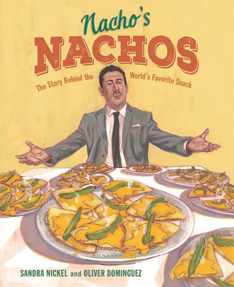 Book cover of Nacho's Nachos: The Story Behind the World's Favorite Snack by Sandra Nickel, Illustrated by Oliver Dominguez, featuring a smiling brown-skinned man with short black hair and mustache wearing a suit, holding his arms wide over a table spread with plates of nachos.