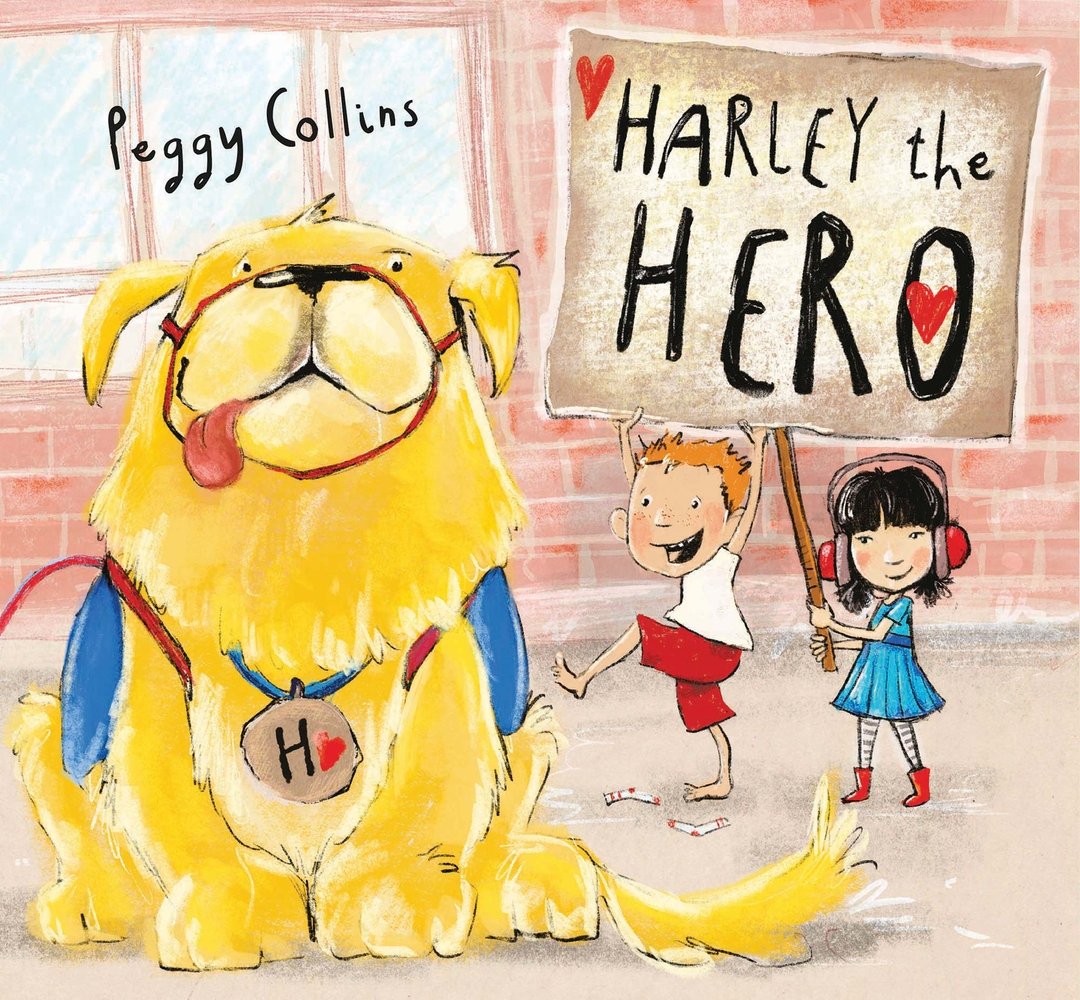 Book cover of Harley the Hero by Peggy Collins, featuring a large, shaggy yellow dog wearing a blue vest and a collar with a large "H" tag; behind him are two light-skinned children - one with short red hair and the other with shoulder-length black hair under noise-cancelling headphones - holding up a cardboard sign with the title.