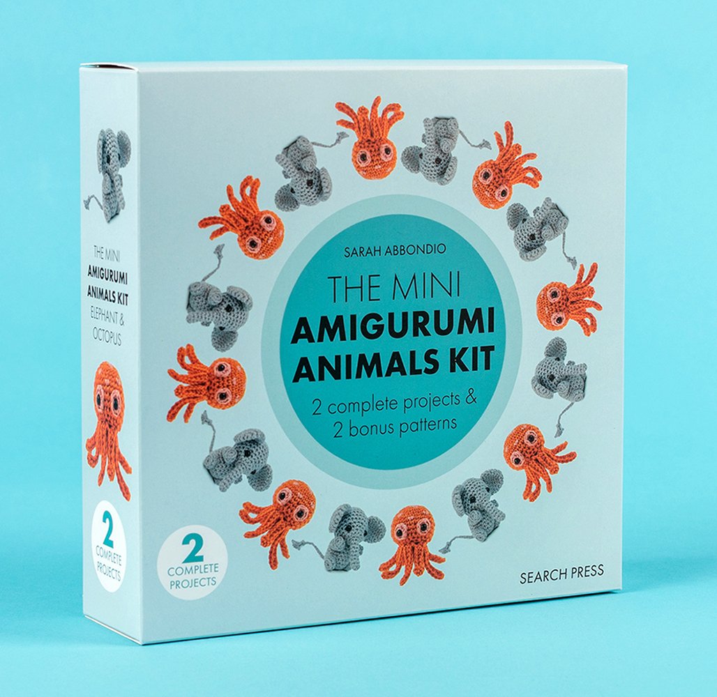 Mini Amigurumi Animals Kit by Sarah Abbondio, a crafting book and kit cover depicting a light blue background with multiple crochet orange jellyfish and a gray elephant, set up in a patterned circle around the title.