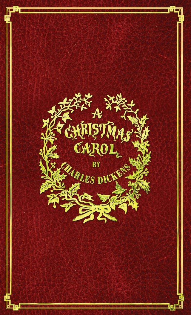 The book has a red leather cover with a decorative gold border. The title, 'A Christmas Carol,' is in the center of a golden wreath.
