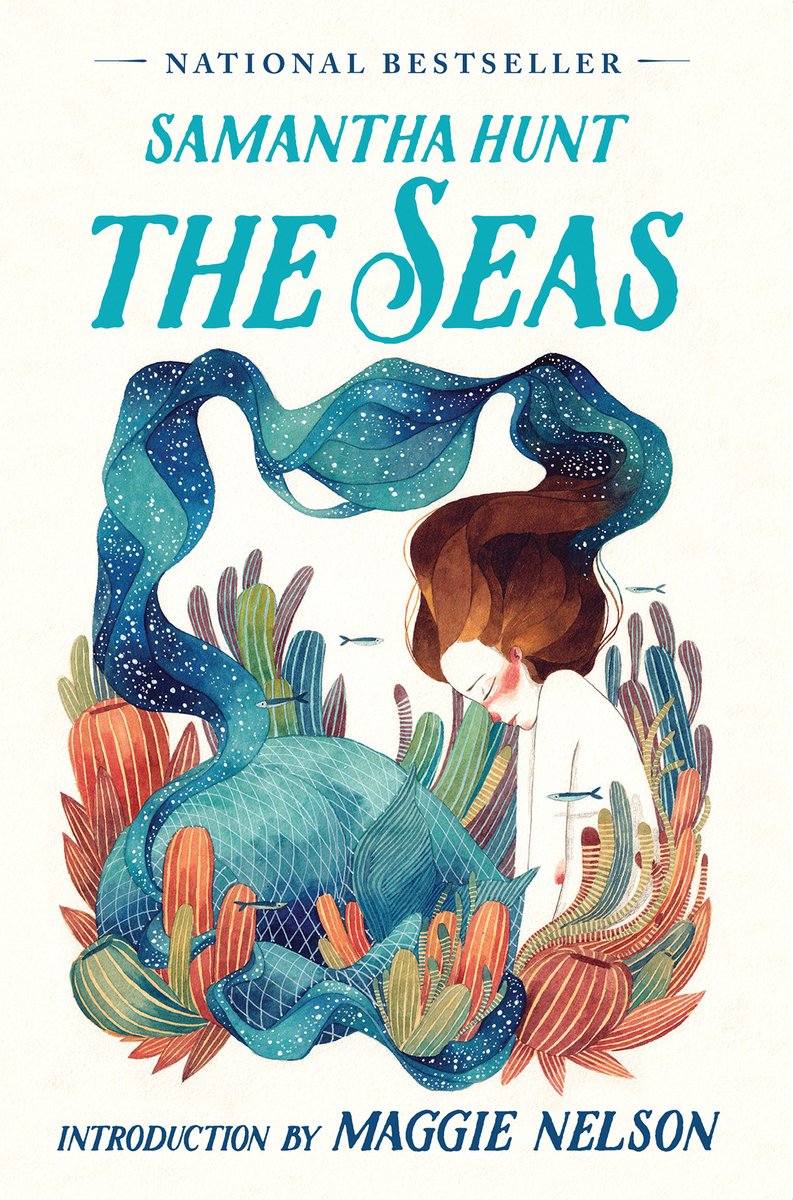 The Seas by Amanda Hunt, a fiction book cover depicting an illustrated mermaid with brown hair and a shimmering blue and green tale, crouched on coral reefs. The background is ivory and the title is in teal letters above the illustration.