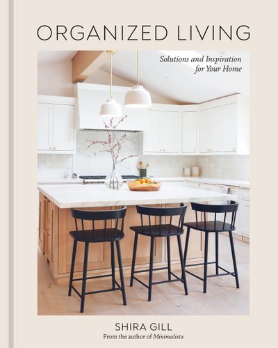 Organized Living: Solutions and Inspiration for Your Home by Shira Gill book cover featuring a kitchen with white cabinets and black chairs.
