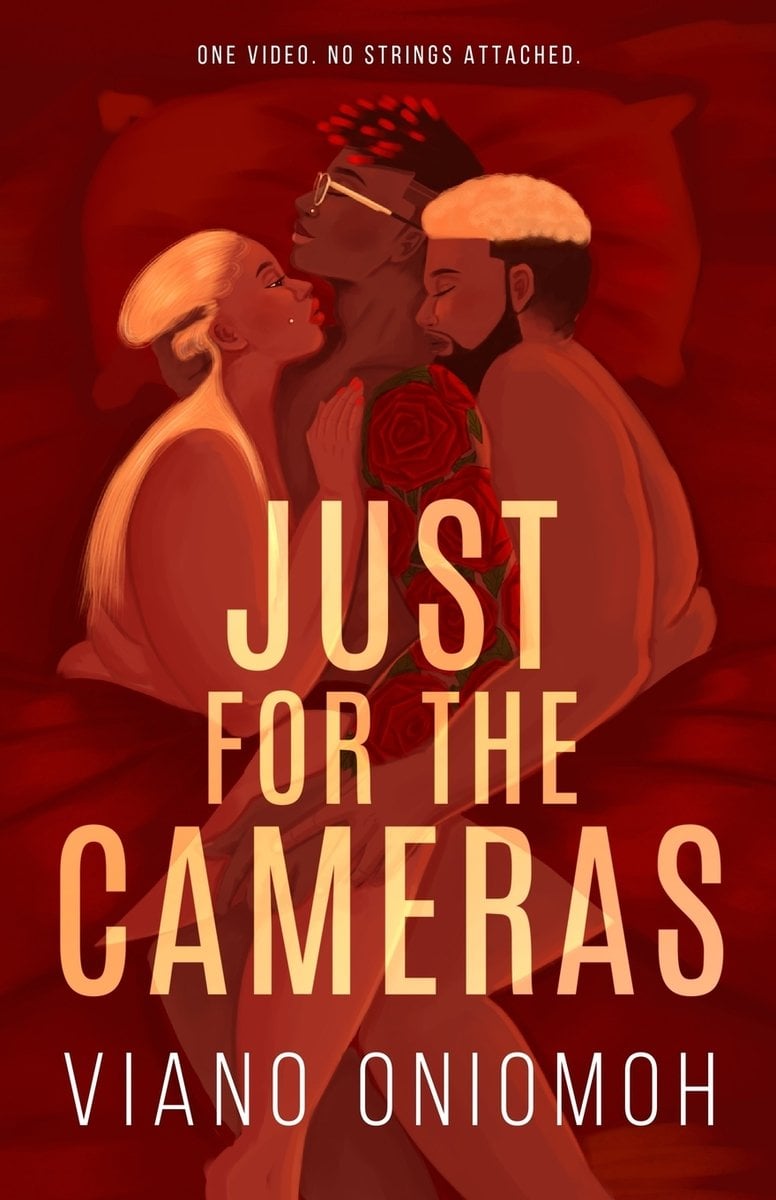 Just for the Cameras by Viano Oniomoh erotic romance book cover depicting two Black men and a Black woman cuddled together in bed